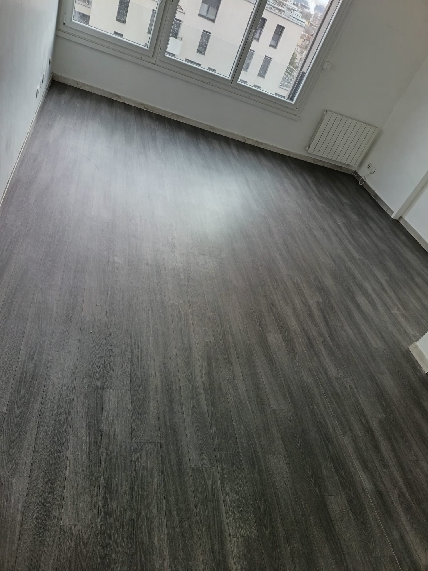 pose-sol-pvc-parquet-gris-lyon-apres Pose de revêtement de sol PVC aspect parquet gris dans un appartement lyonnais : résultat final moderne et soigné.