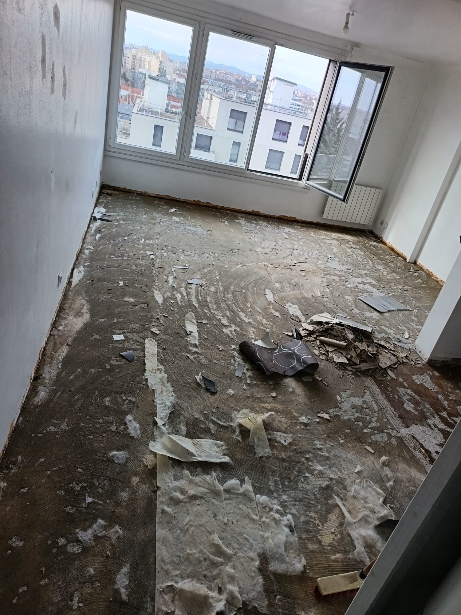 renovation-sol-depose-appartement-lyon-avant Rénovation de sol à Lyon : dépose d'un ancien revêtement usé et support brut à nu avant préparation par RénovToutSols